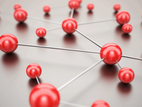Rote Kugeln, verbunden durch dünne Drähte, bilden ein Netzwerk auf einer glatten Oberfläche.