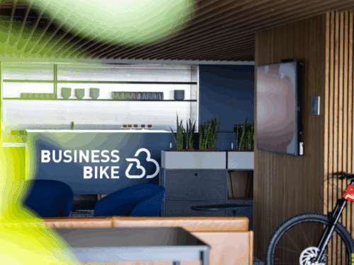Moderne Büroumgebung mit Pflanzen, einem Empfangstresen mit "BUSINESS BIKE"-Logo und einem Fernseher.