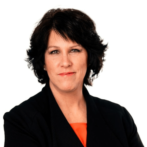 Frau mit dunklen, schulterlangen Haaren, trägt einen schwarzen Blazer und hat einen selbstbewussten Gesichtsausdruck.
