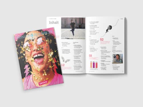 HRM_04_Erfolg_2025_mockup Cover eines Magazins mit einer lächelnden Person, umgeben von goldenen Konfetti, neben einer offenen Seite mit Inhalten.