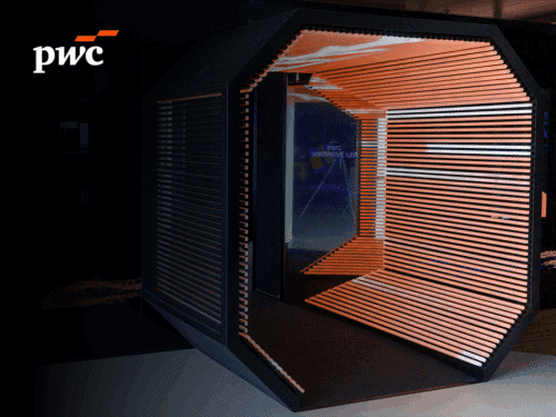 Moderne, hexagonale Kabine mit Holzlamellen und futuristischem Design im PwC Immersive Lab.