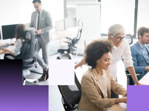 Moderne Büroumgebung mit Mitarbeitern, die an Computern arbeiten, und einem Gespräch zwischen zwei Personen im Vordergrund.
