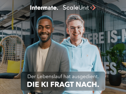 Zwei junge Männer stehen in einem modernen Büro, umgeben von kreativen Arbeitsbereichen und inspirierenden Sprüchen.